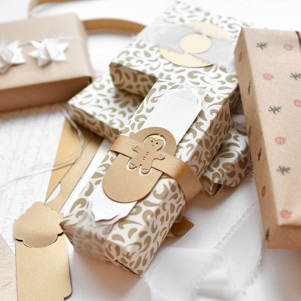 Geschenkboxen mit dekorativer Verpackung, goldenen Akzenten und einem Lebkuchenmann-Anhänger, gestaltet mit Alexandra Renke Motivstanze Lebkuchenmännchen auf eleganten Designpapieren.