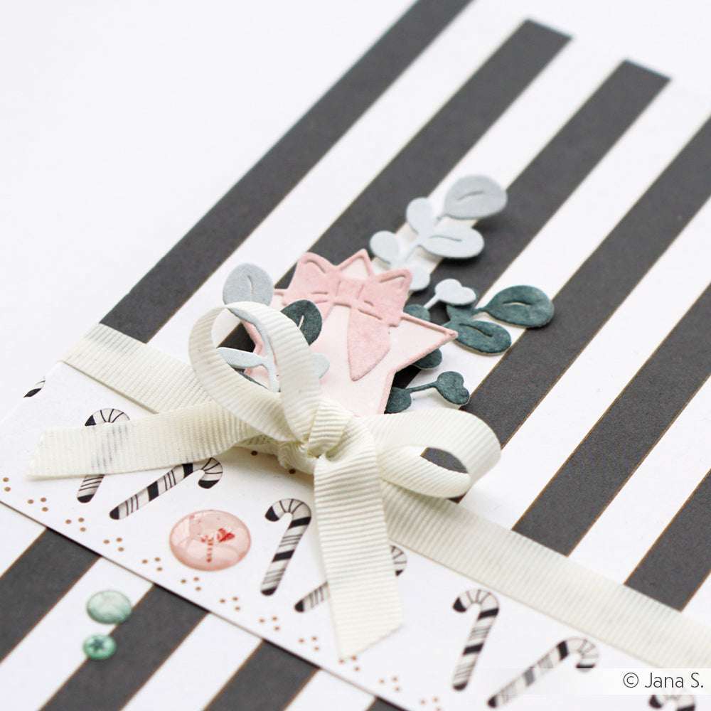 Eine handgemachte Karte von Alexandra Renke mit schwarzen Streifen, Zuckerstangen, einer weißen Schleife, rosa und grünem Designerpapier und festlichen Akzenten, die mit Stanzen wie der Motivstanze Stern mit Schleife hergestellt wurden.