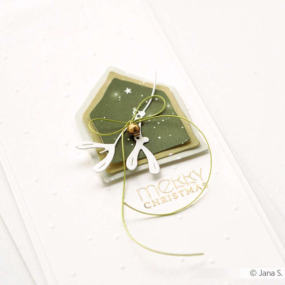 Minimalistische Weihnachtskarte von Alexandra Renke, gestaltet mit DieCut Systemen in Hausform, Rentiergeweih, goldener Schnur und dem Text "Frohe Weihnachten" auf eleganten Designpapieren.