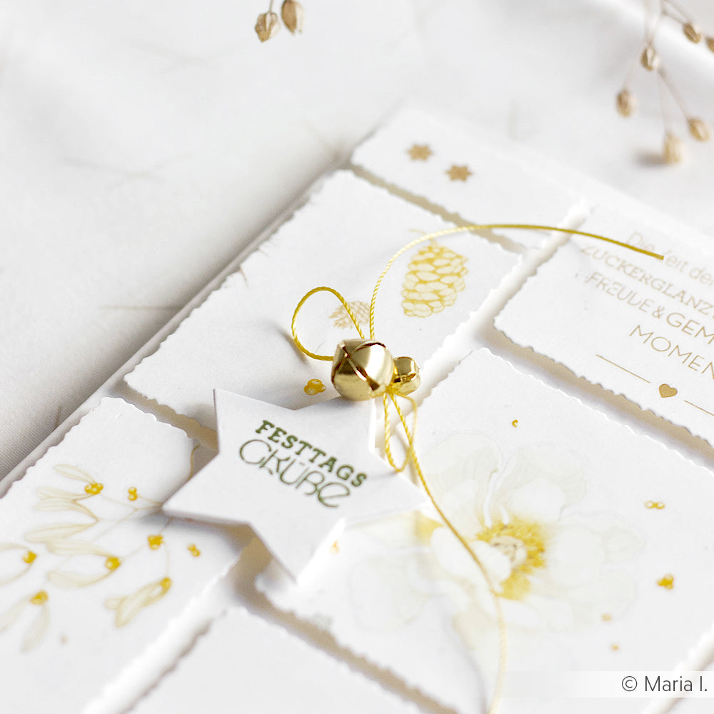 Eine weihnachtliche Grußkarte von Alexandra Renke mit goldenen Akzenten, Glöckchen und einem Stern mit der Aufschrift Festtagsgrüße, hergestellt mit der Motivstanze Stern Etikett und hochwertigen Designpapieren 200g.