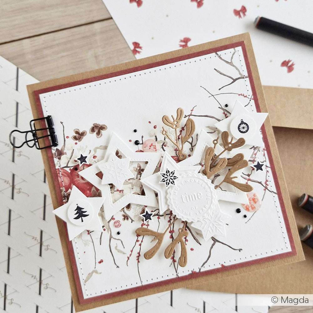 Handgemachte Weihnachtskarte mit Sternformen aus dem Alexandra Renke Motivstanze Sternenzauber Rahmen Set, braunen Zweigen und winterlichen Dekorationen auf weißem Hintergrund. Ideal, um Ihre Lieblingsdesignpapiere zu präsentieren.