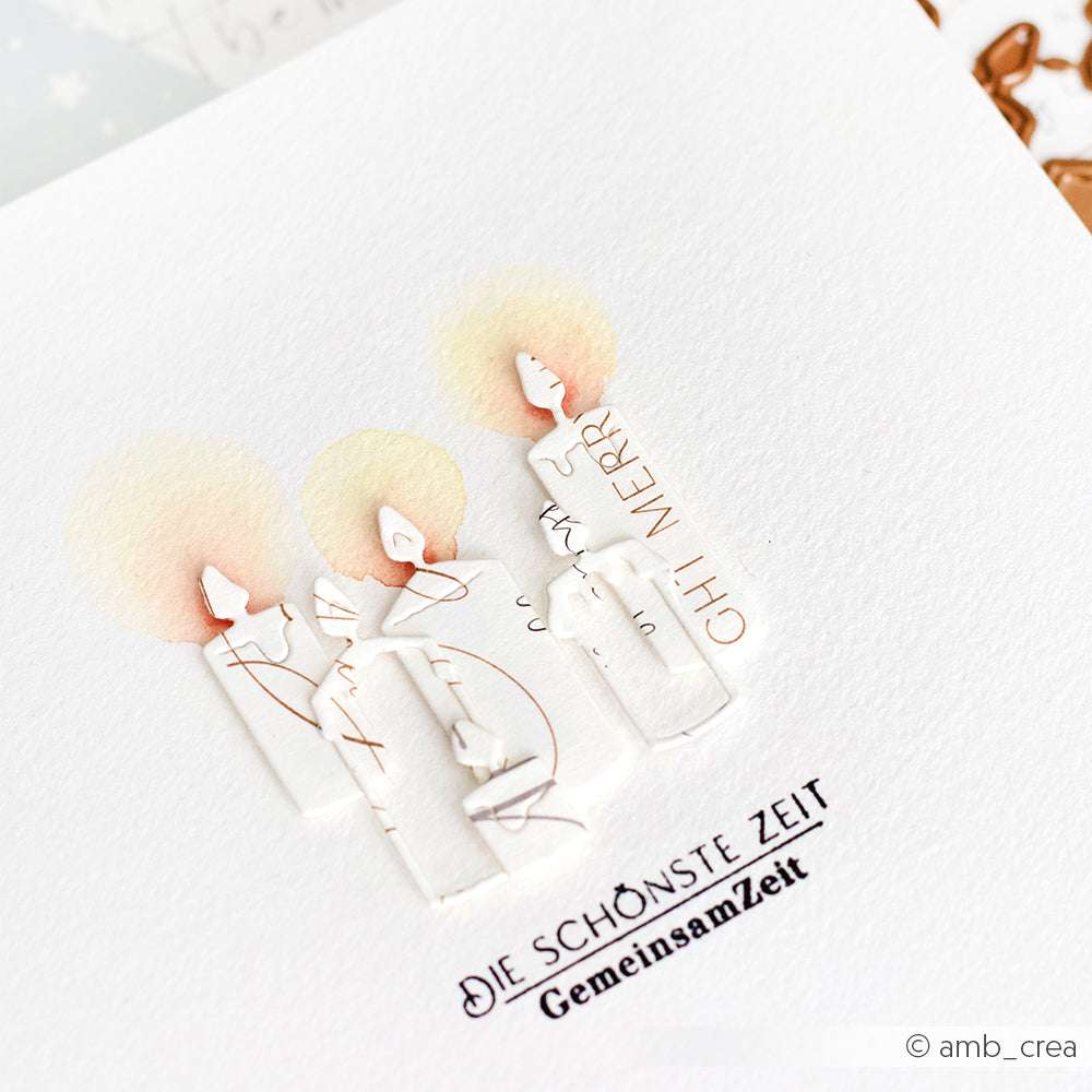 Alexandra Renke Kerzen aus Designpapieren und einem Motivstanze Kerzen Set leuchten sanft in gelb-orange mit dem Schriftzug "DIE SCHÖNSTE ZEIT GemeinsamZeit" darunter.