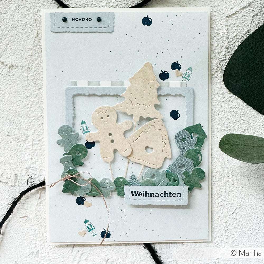 Handgefertigte Weihnachtskarte von Alexandra Renke mit Lebkuchen, Baum und Hausausschnitten, die mit Stanzen für Designpapier und DieCut Systemen hergestellt wurden, grünen Akzenten und dem Text "Weihnachten" in Deutsch.