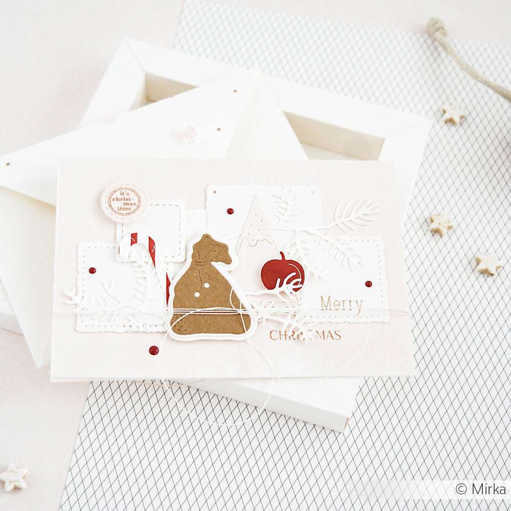 Handgemachte Weihnachtskarte mit Stanzformen von Alexandra Renke, roten Akzenten und dem Text "Frohe Weihnachten" auf weißem Hintergrund.