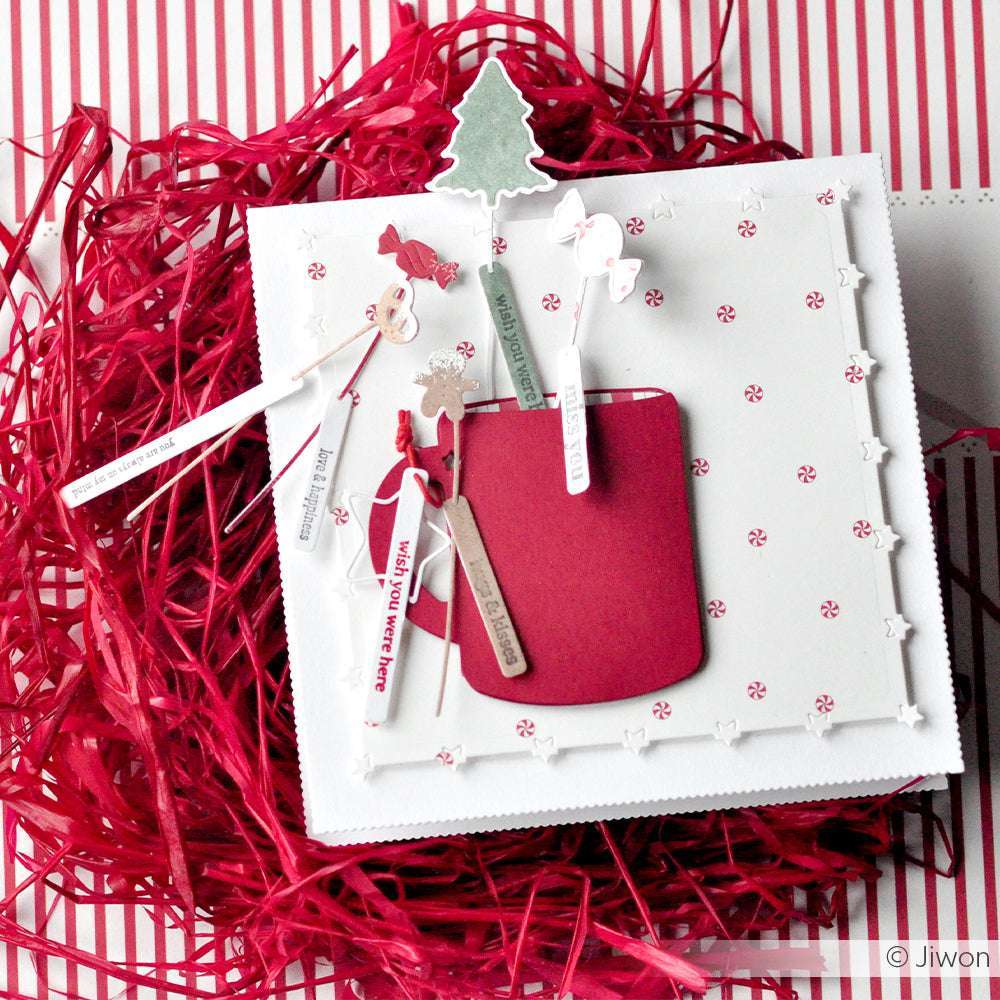 Handgefertigte Weihnachtskarte von Alexandra Renke mit roter Tasche, festlicher Dekoration und Baum auf weiß-rot gestreiftem Hintergrund, hergestellt mit hochwertigen Designpapieren für eine einzigartige Note.