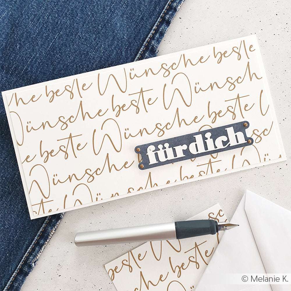 Eine Karte mit dem Schriftzug "Die besten Wünsche" und einem Etikett "Elegantes Etiketten Duo" von Alexandra Renke, daneben ein Stift und ein Briefumschlag.
