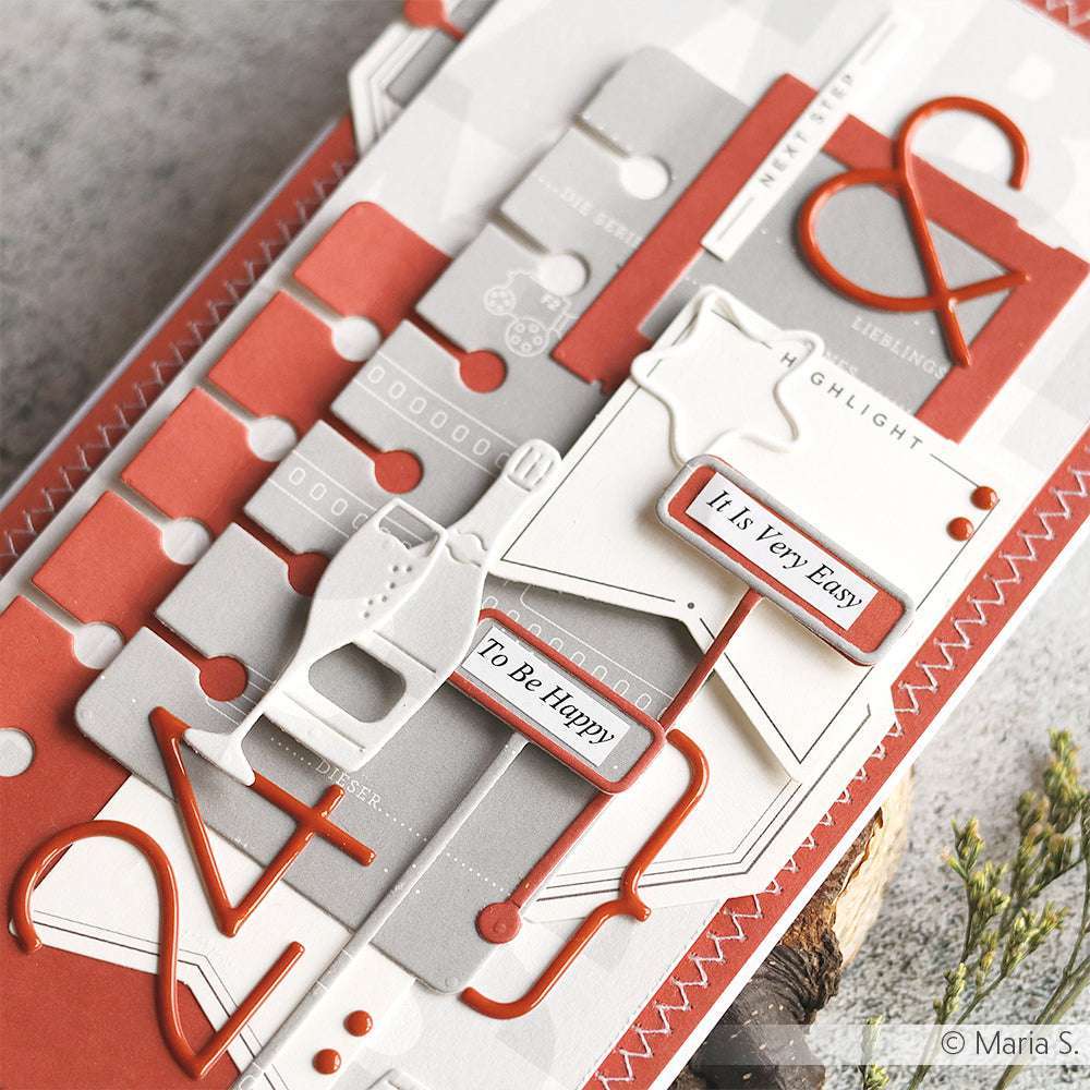 Eine rote und graue Karte von Alexandra Renke mit mehreren Ebenen zeigt geprägte Zahlen, geometrische Formen und Sätze wie "To Be Happy", die mit PAPPcut®ies und Deep Edge Motivstanzen für komplizierte Details hergestellt wurden.