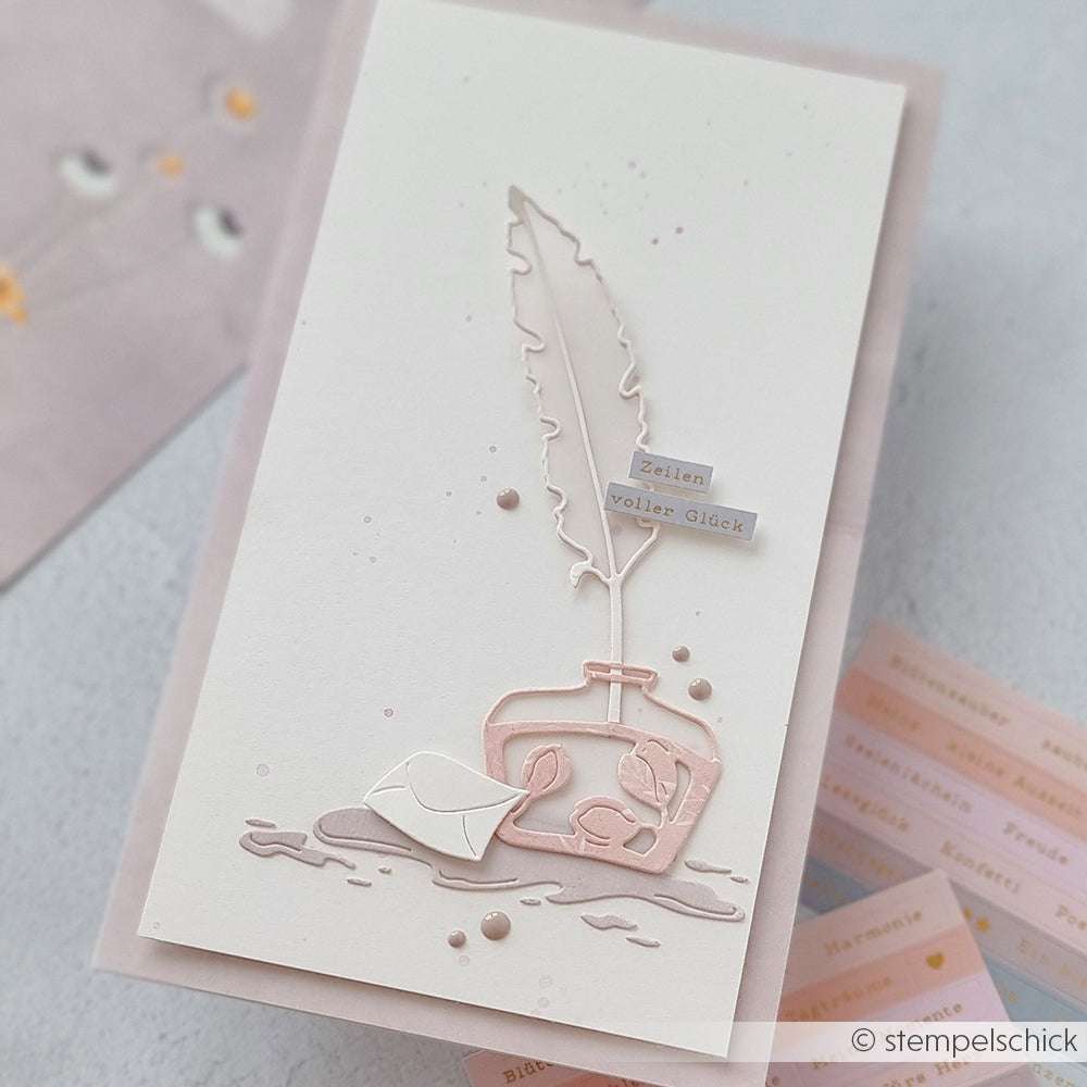Handgefertigte Karte von Alexandra Renke mit Federkiel, Tintenfass und Brief, hergestellt mit der Motivstanze Große Feder und Tinte. Dazu ein kleines Etikett mit der Aufschrift "Zeilen voller Glück".