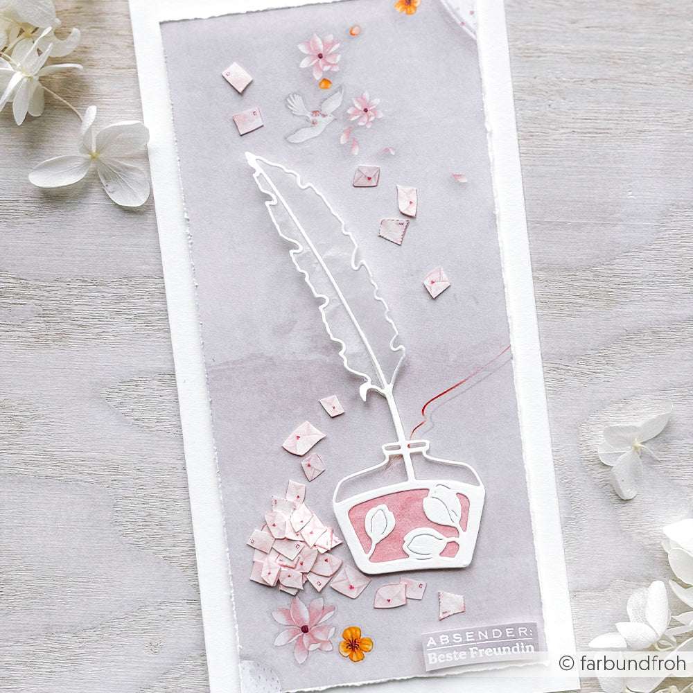 Eine handgefertigte Karte mit Federkiel und Tintenfass und rosa Blütenblättern, hergestellt mit der Motivstanze Große Feder und Tinte aus der PAPPcut®ies Kollektion von Alexandra Renke.