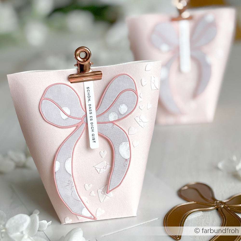 Zartrosa Geschenktüte mit großer Schleife und weißen Herzen, verschlossen mit roségoldenem Clip - gefertigt mit der Alexandra Renke Motivstanze Große Outline Schleife für zusätzlichen Charme.