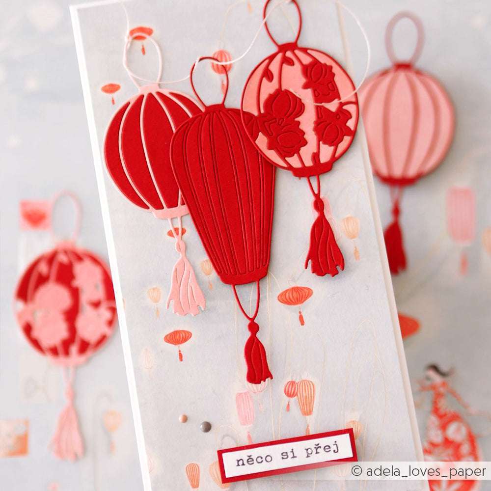 Handgefertigte Karte mit drei roten Papierlaternen, hergestellt mit der Alexandra Renke Motivstanze Lampion, und dem tschechischen Text "něco si přej" am unteren Rand.