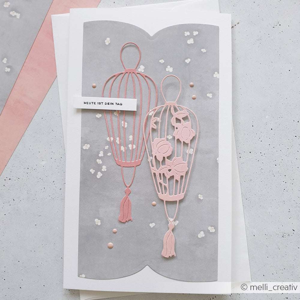 Grußkarte von Alexandra Renke mit zwei rosafarbenen Heißluftballons auf grauem Hintergrund mit kleinen weißen Blumen und eleganten Details, gestaltet mit Deep Edge Motivstanzen und PAPPcut®ies.
