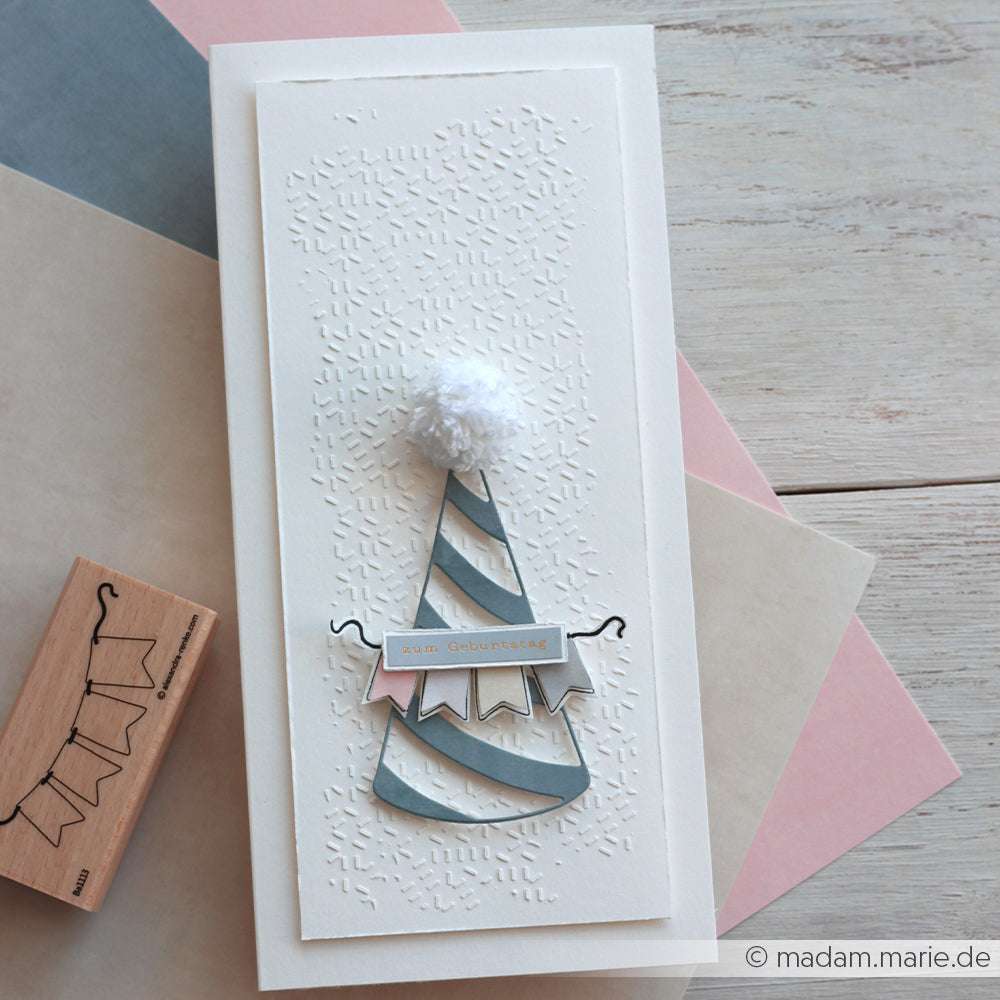 Handgemachte Geburtstagskarte mit einem gestreiften Partyhut, der mit der Stanze Alexandra Renke Großer Partyhut hergestellt wurde, einem weißen Bommel und einer geprägten Textur auf neutralem Hintergrund.