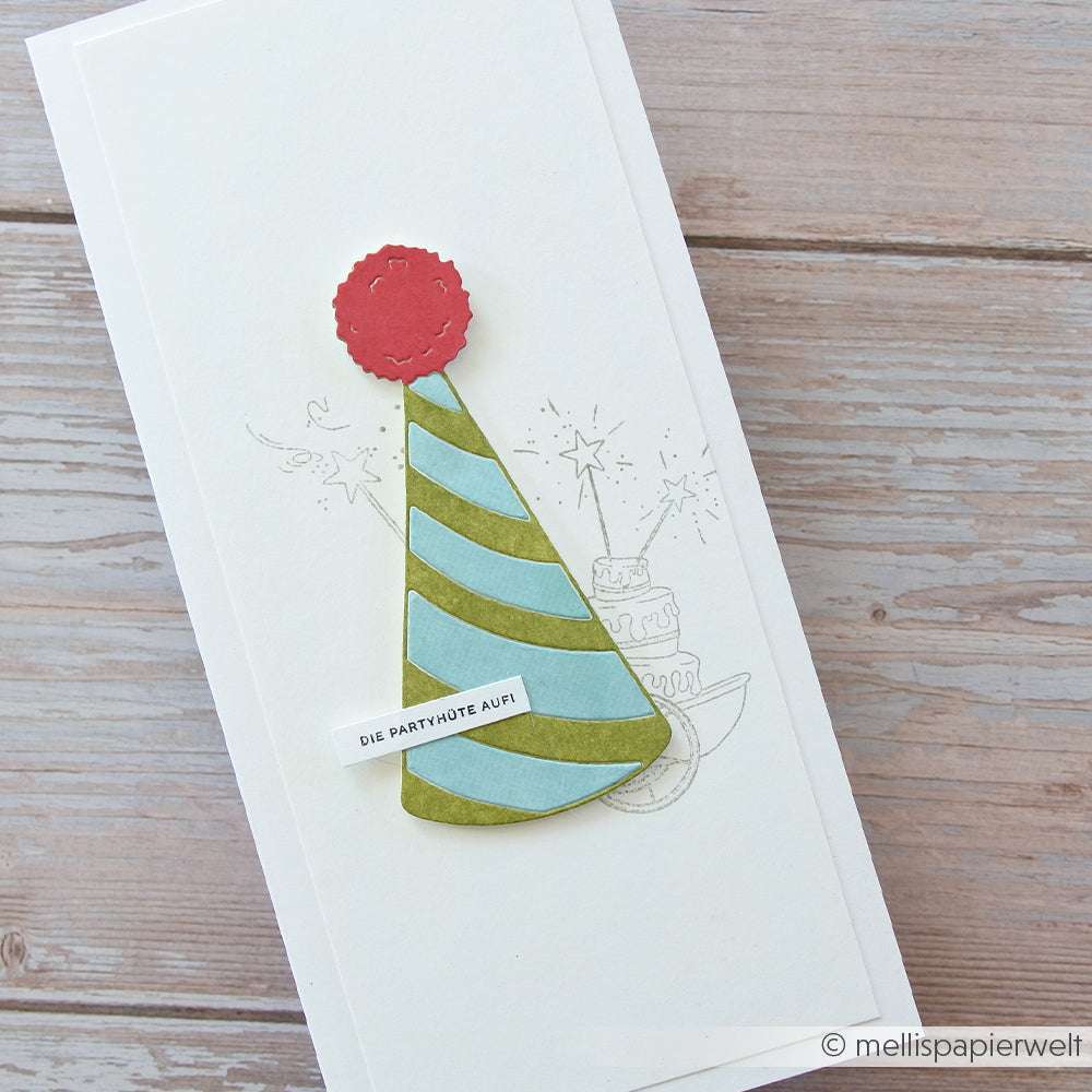 Handgefertigte Karte von Alexandra Renke mit einem grün-blauen Partyhut aus der Motivstanze Großer Partyhut, verziert mit einer roten Bommel, sowie einer dezenten Skizze mit Kuchen und Wunderkerzen - perfekt für festliche Anlässe.
