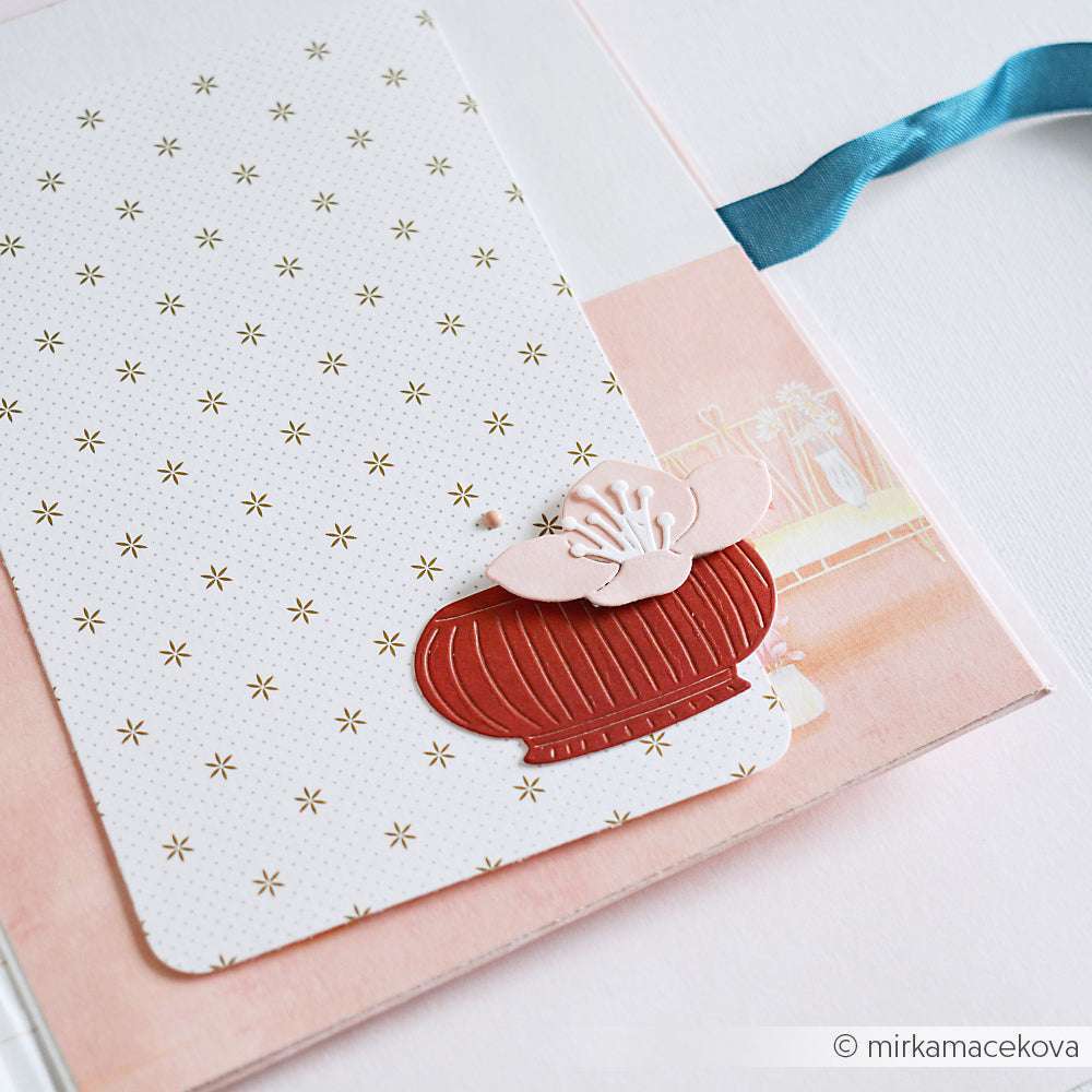 Grußkarte von Alexandra Renke mit einer roten Papiervase aus der Motivstanze Lieblingsvase, rosa Blumenakzenten, auf pastellfarbenem Hintergrund mit blauem Band.