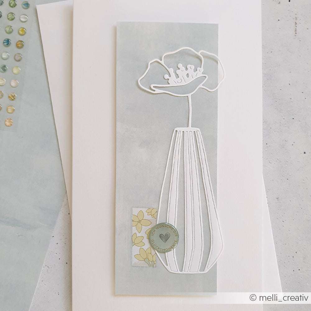 Minimalistische Grußkarte von Alexandra Renke mit einer weiß umrandeten Blume in einer Vase (Motivstanze Große Blumenvase) auf blassblauem Hintergrund, akzentuiert mit kleinen PAPPcut®ies-Details.