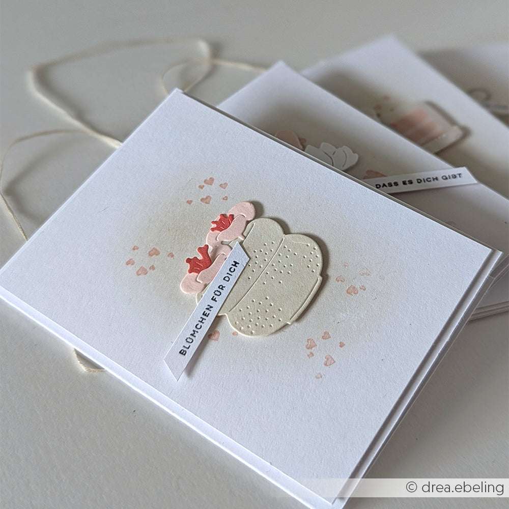 Eine handgefertigte Karte von Alexandra Renke mit einer Vase und Blumen mit "Blümchen für dich" auf weißem Hintergrund, hergestellt mit Deep Edge Motivstanzen für präzise Details.