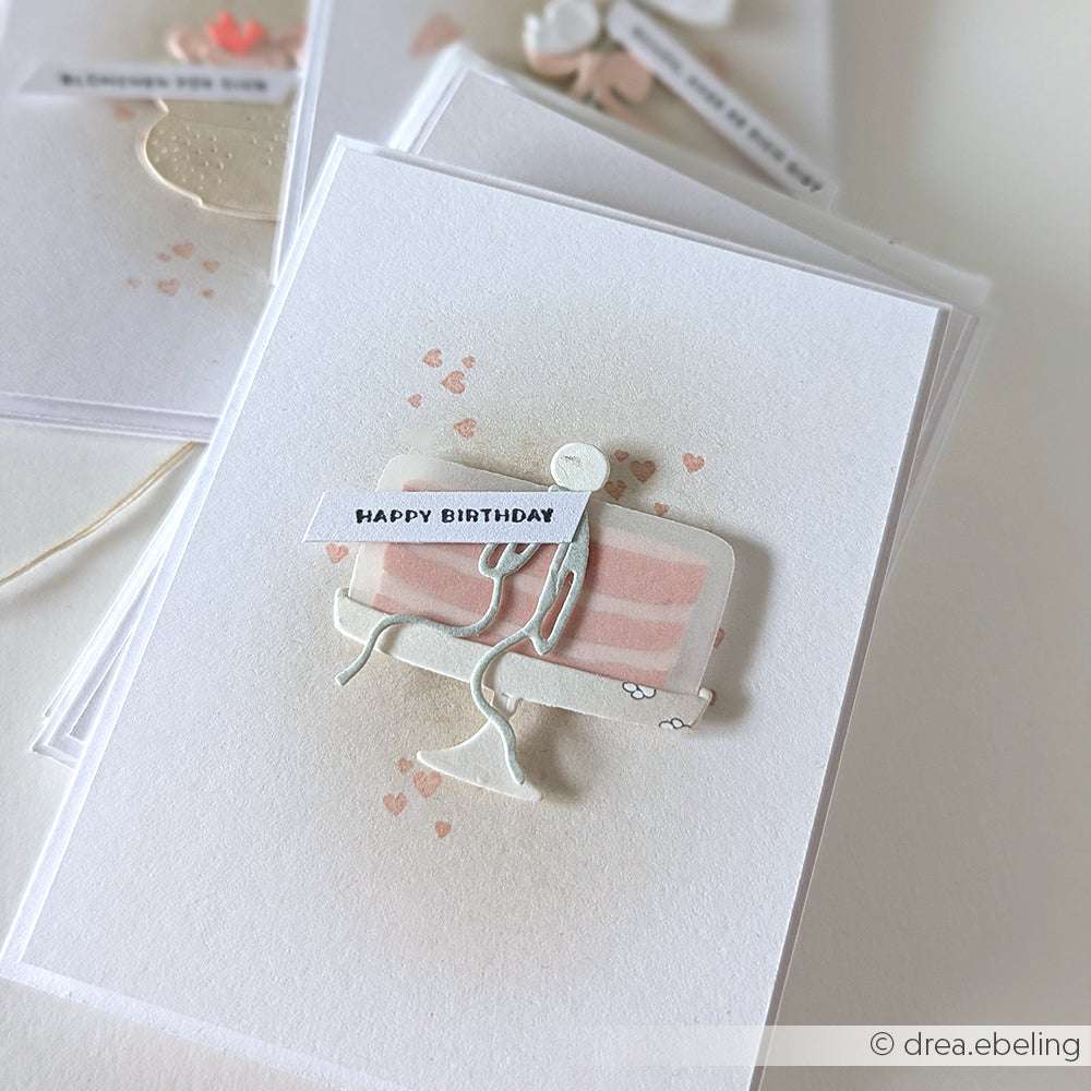 Die handgefertigte Karte von Alexandra Renke zeigt eine schlichte Figur, die ein Happy-Birthday-Zeichen hält, umgeben von kleinen rosa Herzen - perfekt für die Kombination mit Deep Edge Motivstanzen Designs.