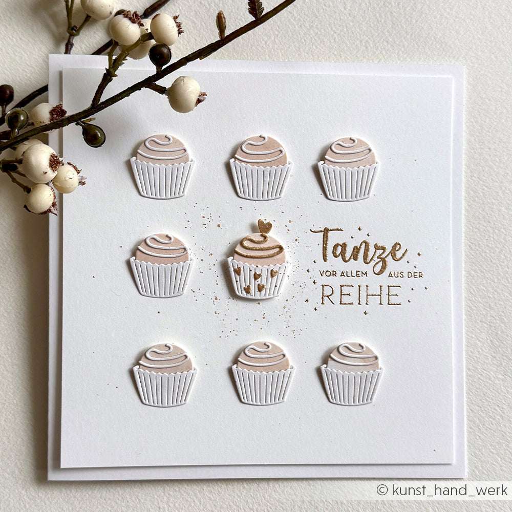 Eine Karte von Alexandra Renke mit neun Cupcake-Motiven - eines davon mit einem Herz -, die mit PAPPcut®ies und Deep Edge Motivstanzen gestaltet wurden, mit dem deutschen Text "Tanze vor allem aus der Reihe".