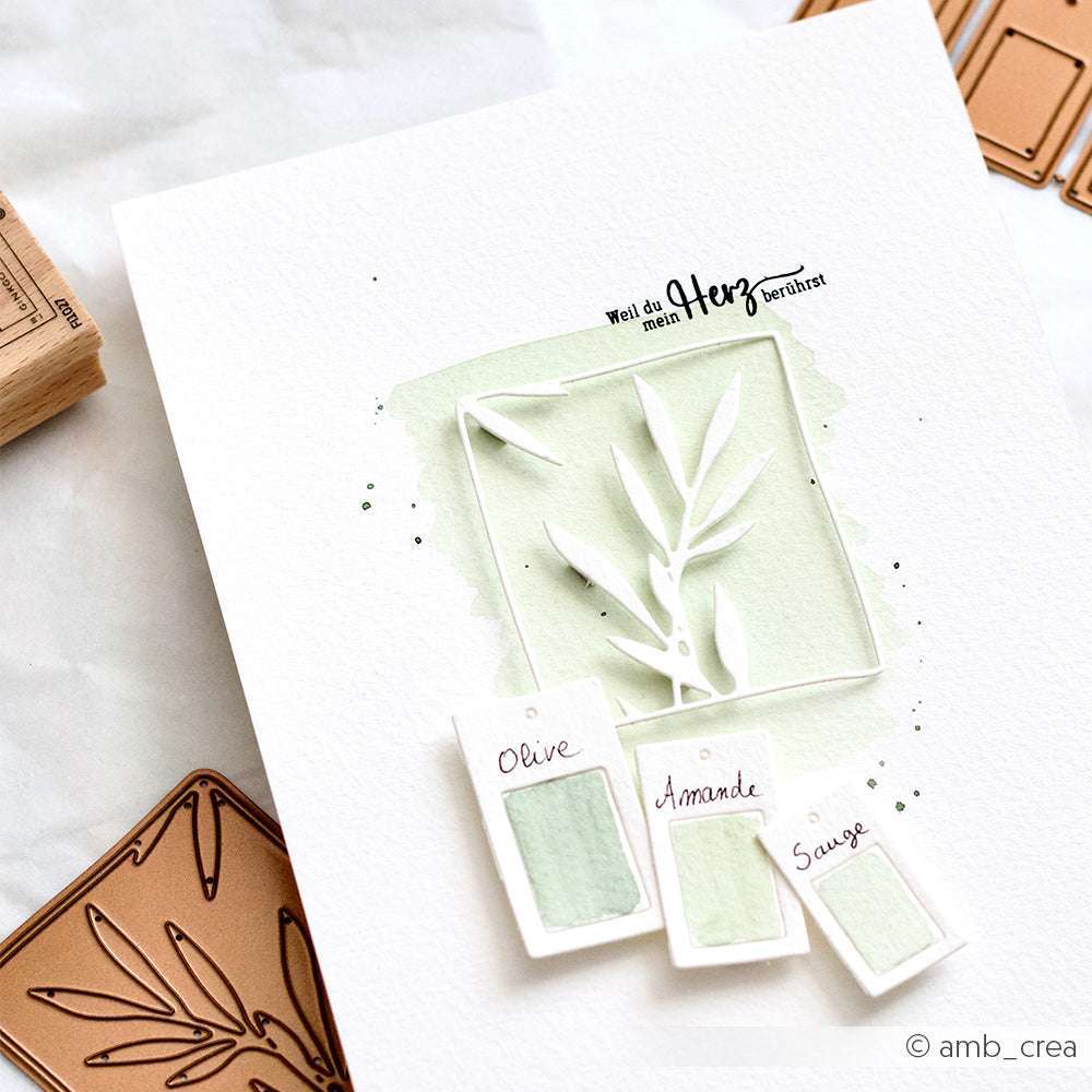 Eine handgemachte Karte von Alexandra Renke mit einem Blattausschnitt mit Deep Edge Stanzen, hellgrüner Aquarellfarbe und beschrifteten Mustern: Olive, Amande, Sauge.