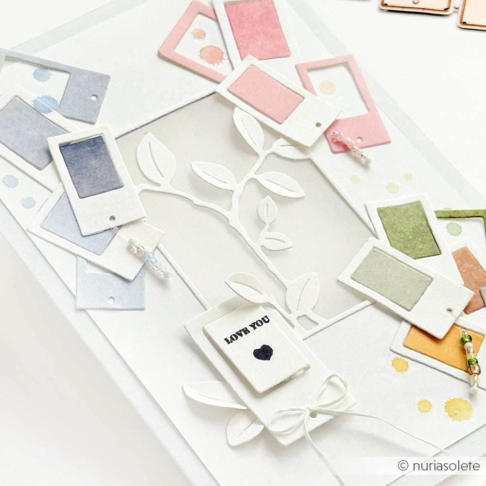Handgemachte Karte mit pastellfarbenen Fotorahmen von Alexandra Renke, Blattausschnitten mit Deep Edge Motivstanzen, Perlen und einem kleinen "LOVE YOU"-Anhänger mit Herz.