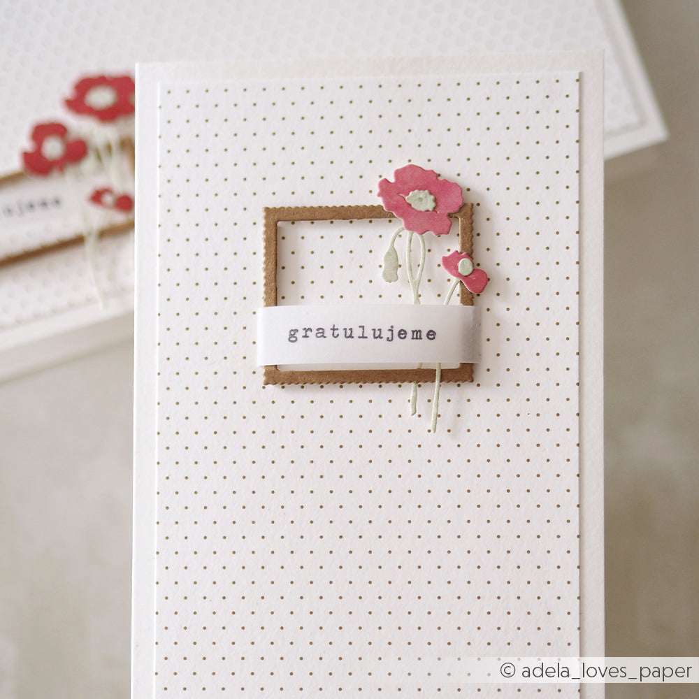 Handgefertigte Karte mit roten Papierblumen, einem braunen Rahmen, der mit Deep Edge Motivstanzen erstellt wurde, und "gratulujeme" auf einem gepunkteten weißen Hintergrund. Ideal für besondere Anlässe. Marke: Alexandra Renke.