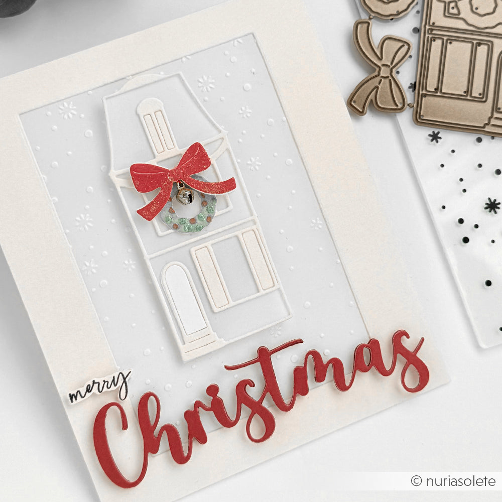 Handgefertigte Weihnachtskarte auf hochwertigen Designpapieren von Alexandra Renke mit einem Haus aus Motivstanze Großes Haus schmal, festlicher Prägung, rotem Schleifenkranz und dem Text Frohe Weihnachten".