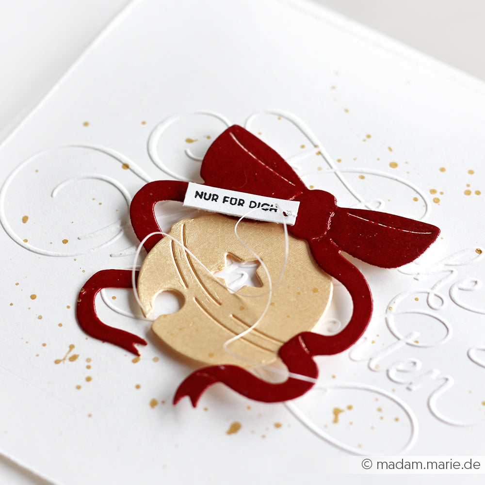 Eine weiße Karte von Alexandra Renke mit roter Schleife, beigem Ornament und einem "Nur für dich"-Schriftzug, gestaltet mit feinem Designerpapier und der Fröhlichen Sternenglocke.