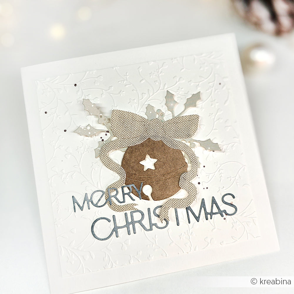 Quadratische Weihnachtskarte von Alexandra Renke mit geprägter Stechpalme, Glocke und Schleife, gestaltet mit eleganter Motivstanze und Designpapieren. Abgeschlossen mit dem silbernen Schriftzug "Merry Christmas".