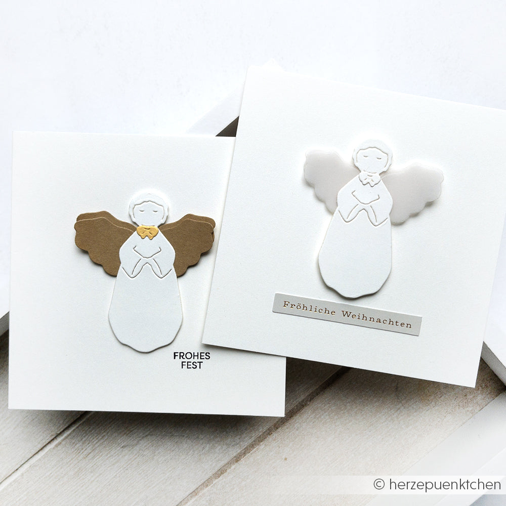 Zwei handgefertigte Weihnachtskarten mit Engelmotiven aus der Alexandra Renke Motivstanze Sanfter Engel und festlichen deutschen Grüßen auf weißem Hintergrund.