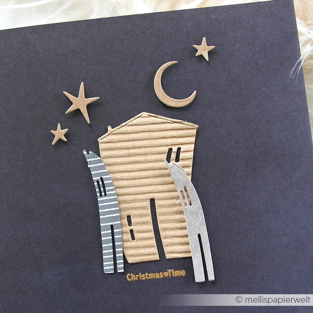 Handgemachte Weihnachtskarte mit einem Wellblechhaus, zwei stilisierten Katzen, Sternen und einer Mondsichel auf dunklem Hintergrund, gestaltet mit dem Motivstanze Nachthimmel-Set von Alexandra Renke und hochwertigen Designpapieren.