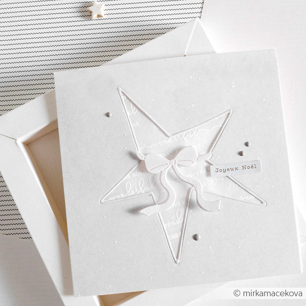 Weiße Weihnachtskarte mit Stern und Schleife, erstellt mit Alexandra Renke Motivstanze Großer Stern mit Schleife Dies und Joyeux Noël Text auf weißem Hintergrund.