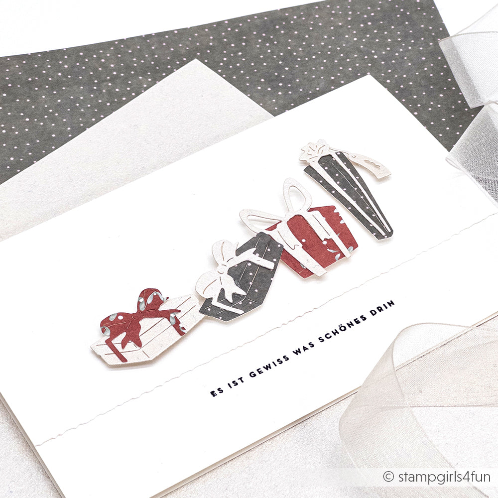 Handgemachte Karte von Alexandra Renke mit vier rot-schwarzen Geschenkschachteln aus dem Motivstanze Geschenke Trio und hochwertigem Designpapier. Der deutsche Text lautet: Es ist gewiss was Schönes drin.