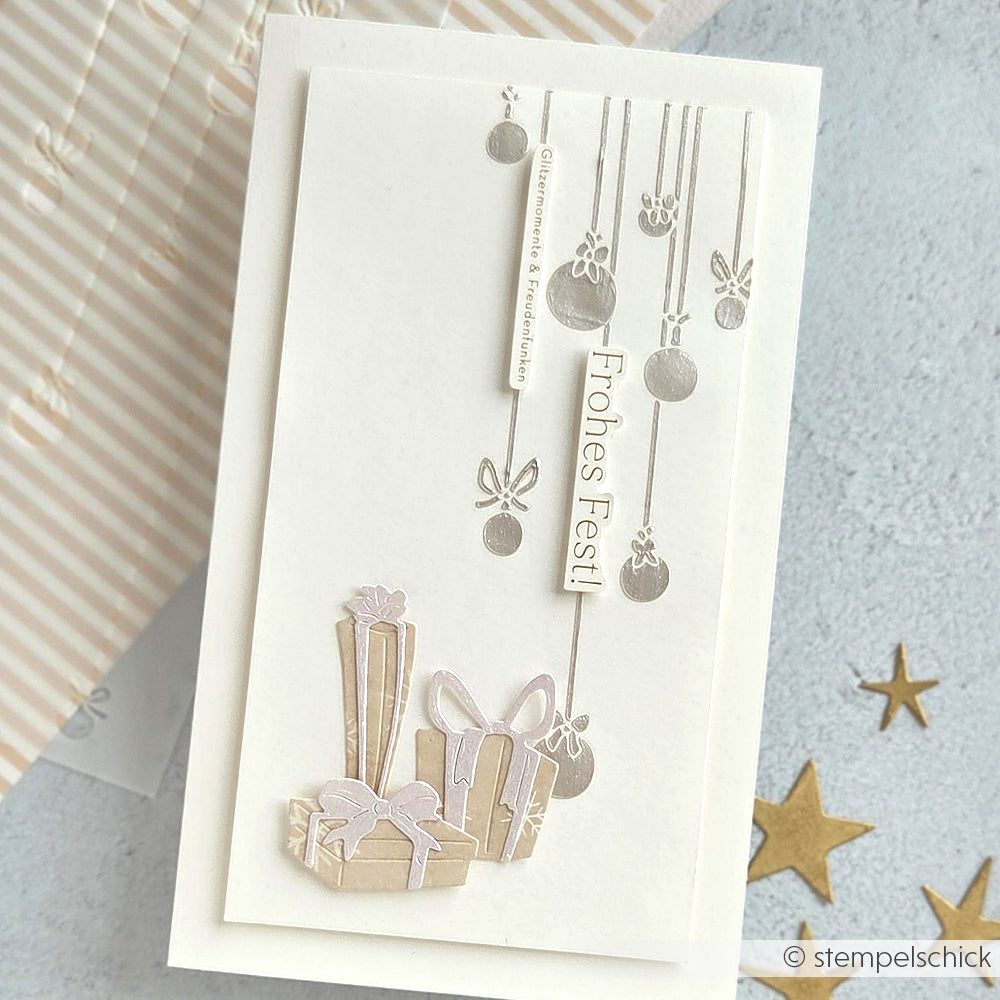 Weiße Weihnachtskarte von Alexandra Renke mit silbernen Ornamenten und "Frohes Fest!" über drei eingepackten Geschenken, hergestellt mit der Motivstanze Geschenke Trio aus robusten 100% Stahlstempeln.