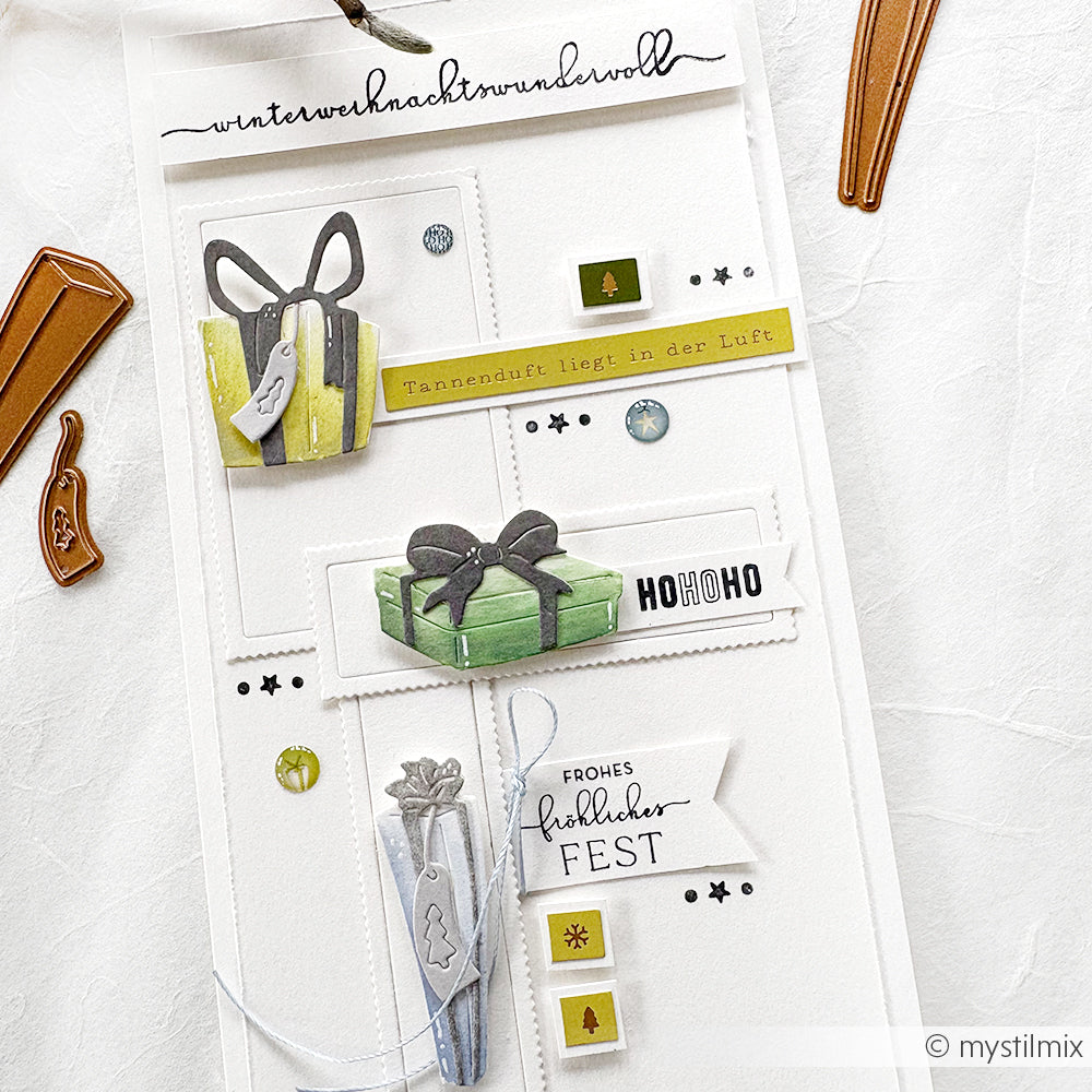 Eine handgemachte Weihnachtskarte mit grünen Geschenkschachteln aus dem Alexandra Renke Motivstanze Geschenke Trio, deutschen Grüßen und festlichen Verzierungen.