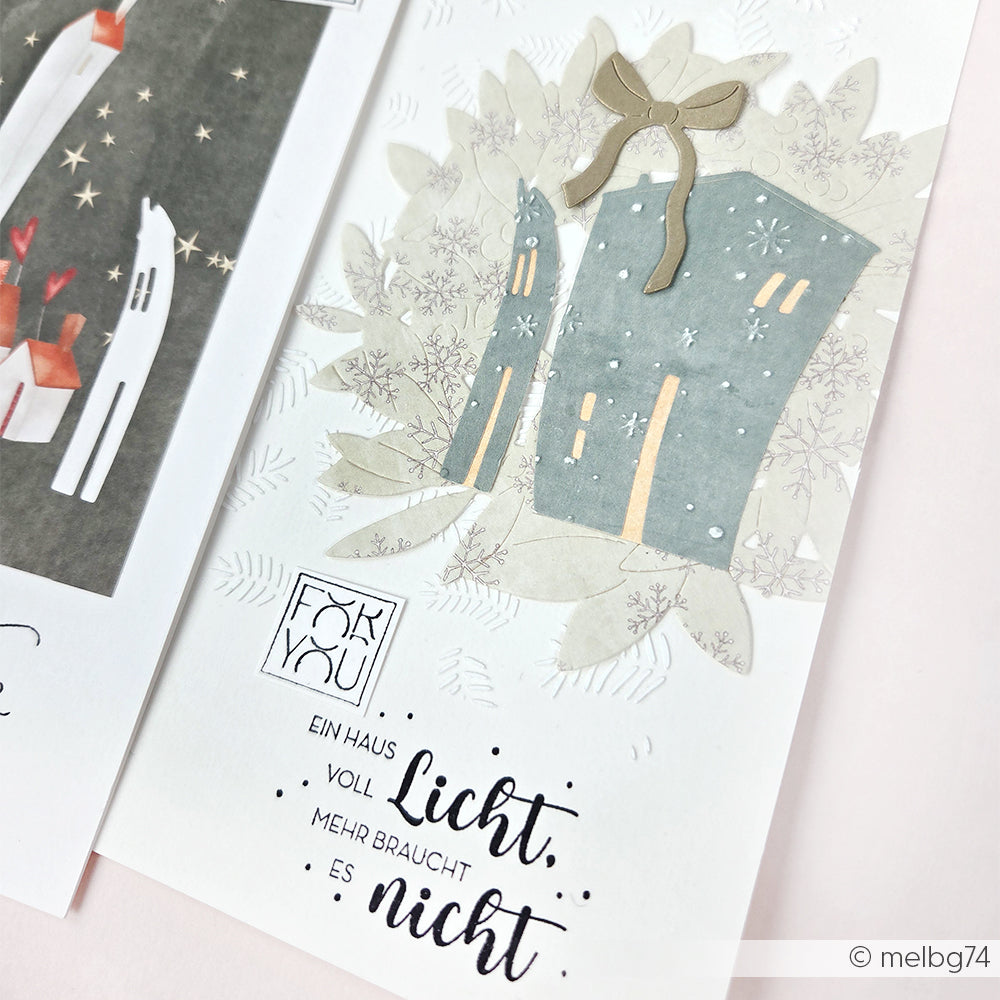 Handgefertigte Karte von Alexandra Renke mit illustrierten Häusern, Schneeflocken und dem Text "Ein Haus voll Licht, mehr braucht es nicht", hergestellt mit Designpapieren und der Motivstanze Schiefe Häuser für eine charmante Note.