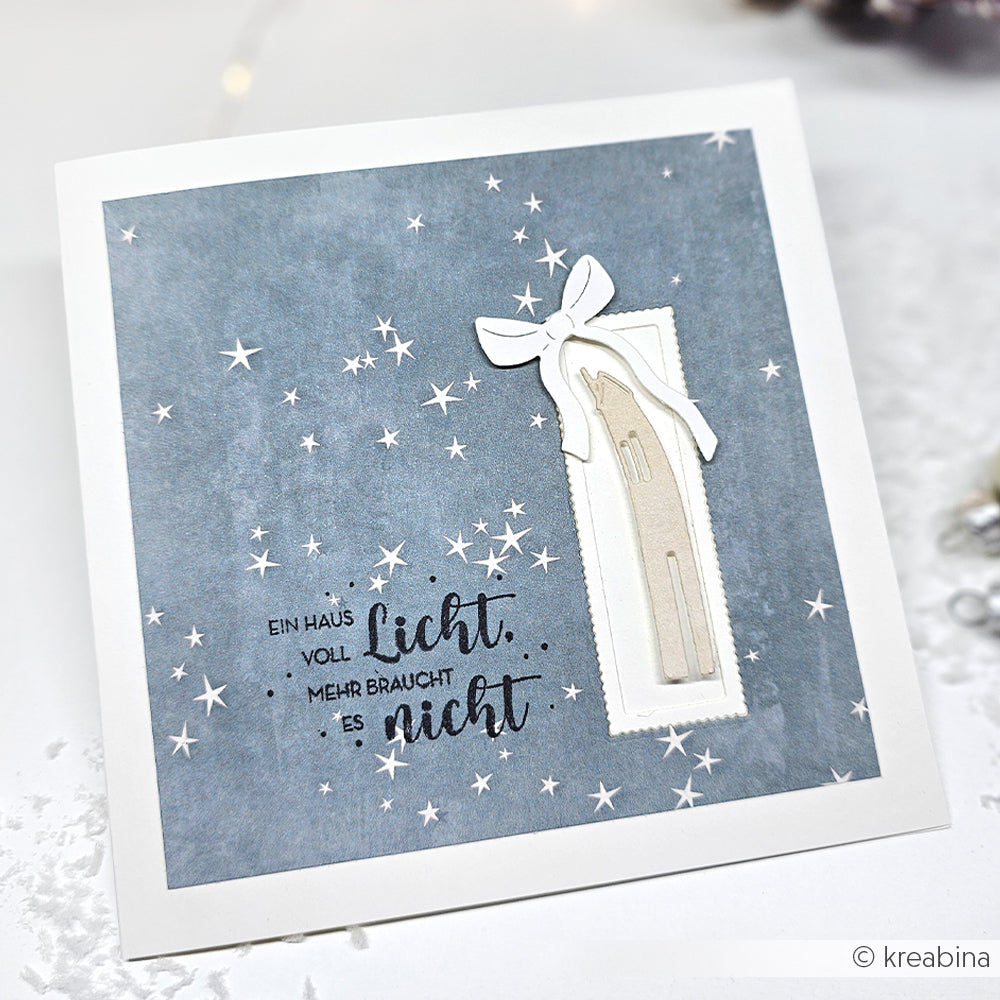 Quadratische Karte von Alexandra Renke aus Designpapieren mit blauem Sternenhintergrund, mit einer gestanzten weißen Kerze und einem deutschen Text über Licht auf der linken Seite.