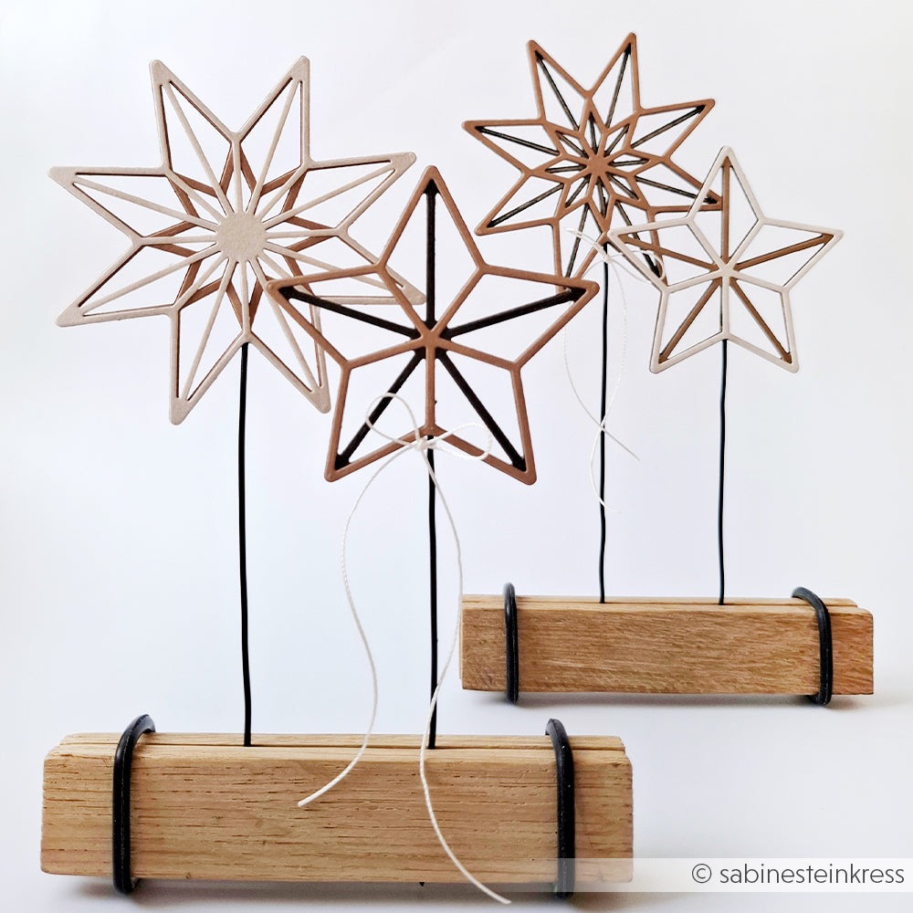 Set mit vier Holzsternen auf Ständern mit Drahthalterungen und Holzsockeln von Alexandra Renke, ideal zur Präsentation von Designpapieren oder zur Verwendung in Stanzsystemen, abgebildet auf weißem Hintergrund.