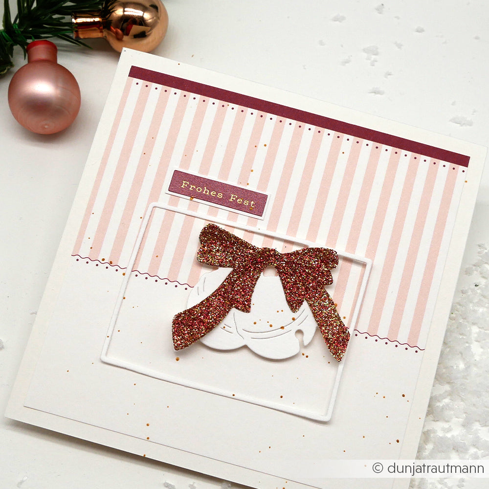 Quadratische Weihnachtskarte von Alexandra Renke mit rosa Streifen, glitzernder roter Schleife, Text "Frohes Fest" und Ornament-Hintergrund. Hergestellt aus hochwertigen Designpapieren und einzigartiger Motivstanze für einen festlichen Touch.
