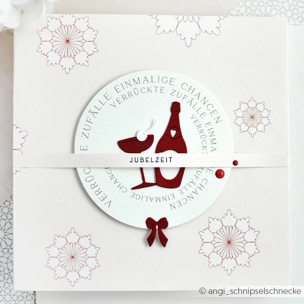 Weiße Karte mit roten Blumenmustern, Weinflasche, Glas und deutschem Text in einem kreisförmigen Design - hergestellt mit der Motivstanze von Alexandra Renke aus dem Fröhliche Drinks Set.