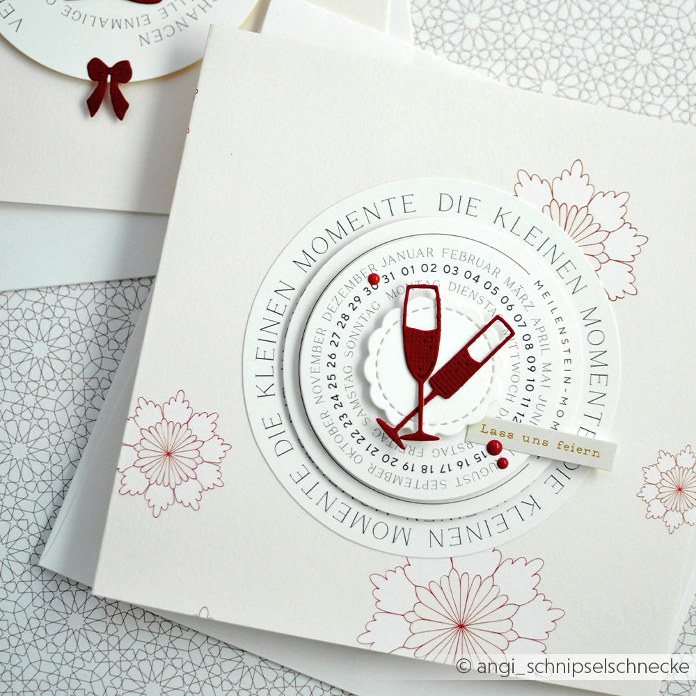 Quadratische Karte von Alexandra Renke mit zwei roten Sektgläsern, deutschem Text und einem floralen Hintergrund - gestaltet mit Designpapieren und der Motivstanze Fröhliche Drinks Stanzsysteme für einen festlichen Look.