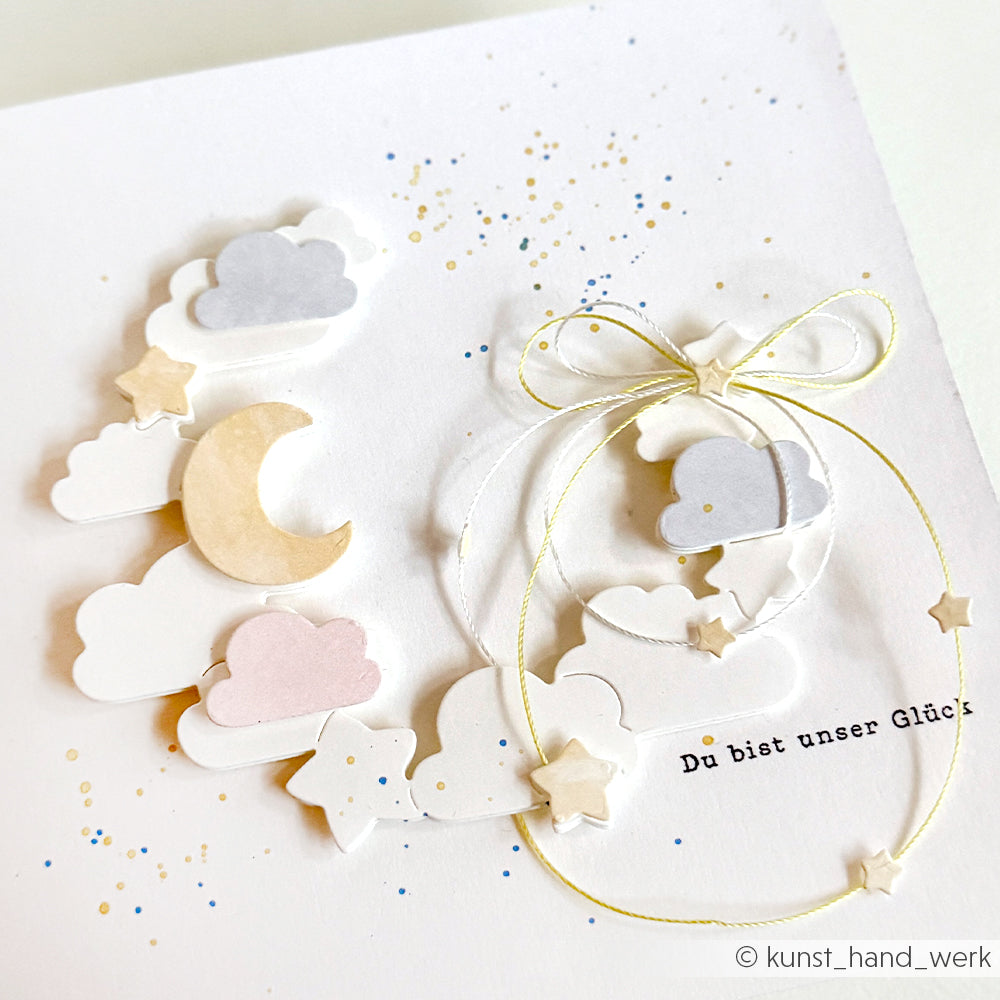 Handgemachte Karte von Alexandra Renke mit pastellfarbenen Wolken, Sternen, Mondsichel und Schleife. Hergestellt mit Motivstanze Nachthimmelkranz und Designpapieren. Text: Du bist unser Glück.