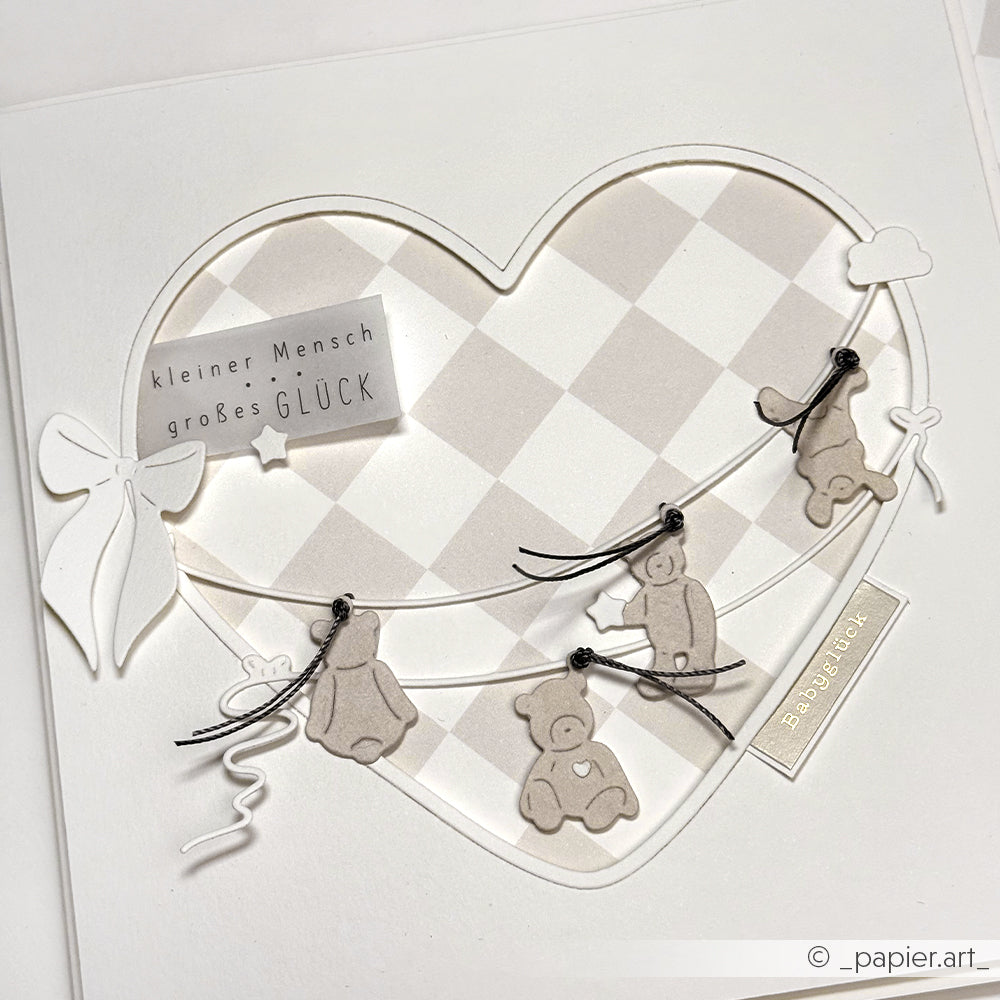 Handgefertigte Alexandra Renke Karte mit Bären an Schnüren, einer Herzform aus Motivstanze Herz und "kleiner Mensch großes Glück" - mit viel Liebe aus hochwertigen Designpapieren gefertigt.