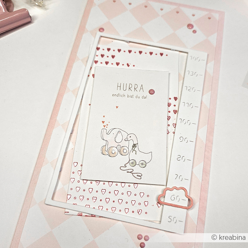 Alexandra Renke Grußkarte mit Spielzeugillustrationen, Herzmustern und deutschem Text, um die Ankunft eines Babys zu feiern - hergestellt mit Motivstanze für bezaubernde Ausschneidedetails.