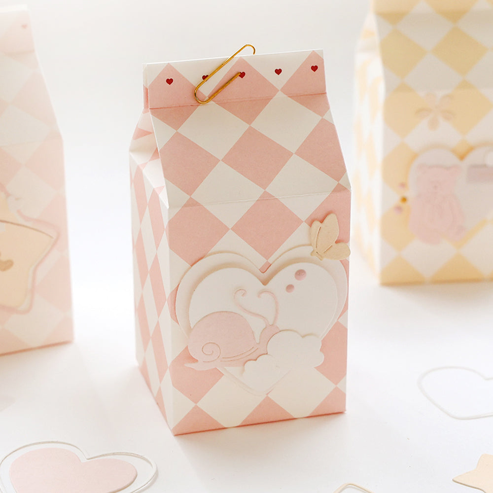 Rosa-weiß karierte Geschenkbox von Alexandra Renke mit Herz- und Schneckenmotiv, gefertigt aus Designpapier und mit einer goldenen Büroklammer versehen.