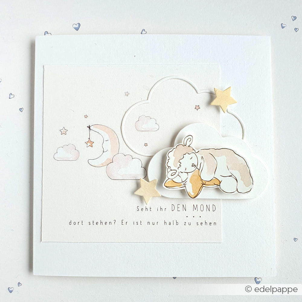 Handgefertigte Karte von Alexandra Renke mit einem schlafenden Lamm, Sternen, Wolken und Mond in einem zarten Wolkenrahmen; mit deutschem Text unter der Mondillustration.