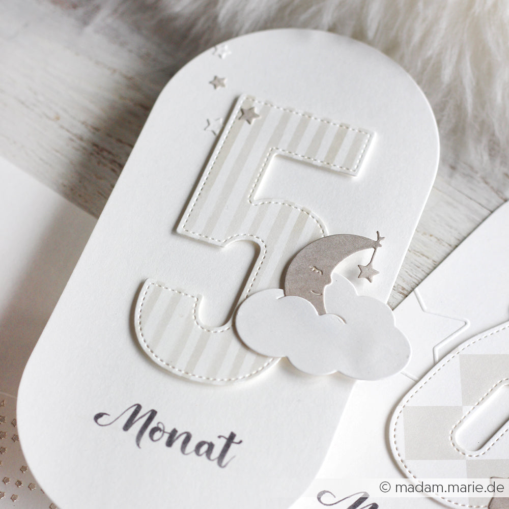 Weiße Karte von Alexandra Renke mit der gestreiften Zahl 5, grauem Mond, Sternen und Wolken, präzise mit DieCut Systemen hergestellt. Unten ist "Monat" aufgedruckt.