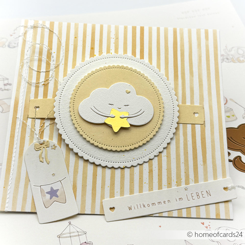 Handgefertigte Alexandra Renke Karte mit einer lächelnden Wolke und einem gelben Stern auf gestreiftem Hintergrund mit der Aufschrift "Willkommen im LEBEN", hergestellt mit der Motivstanze Wolken-Umarmung für einzigartige Details.