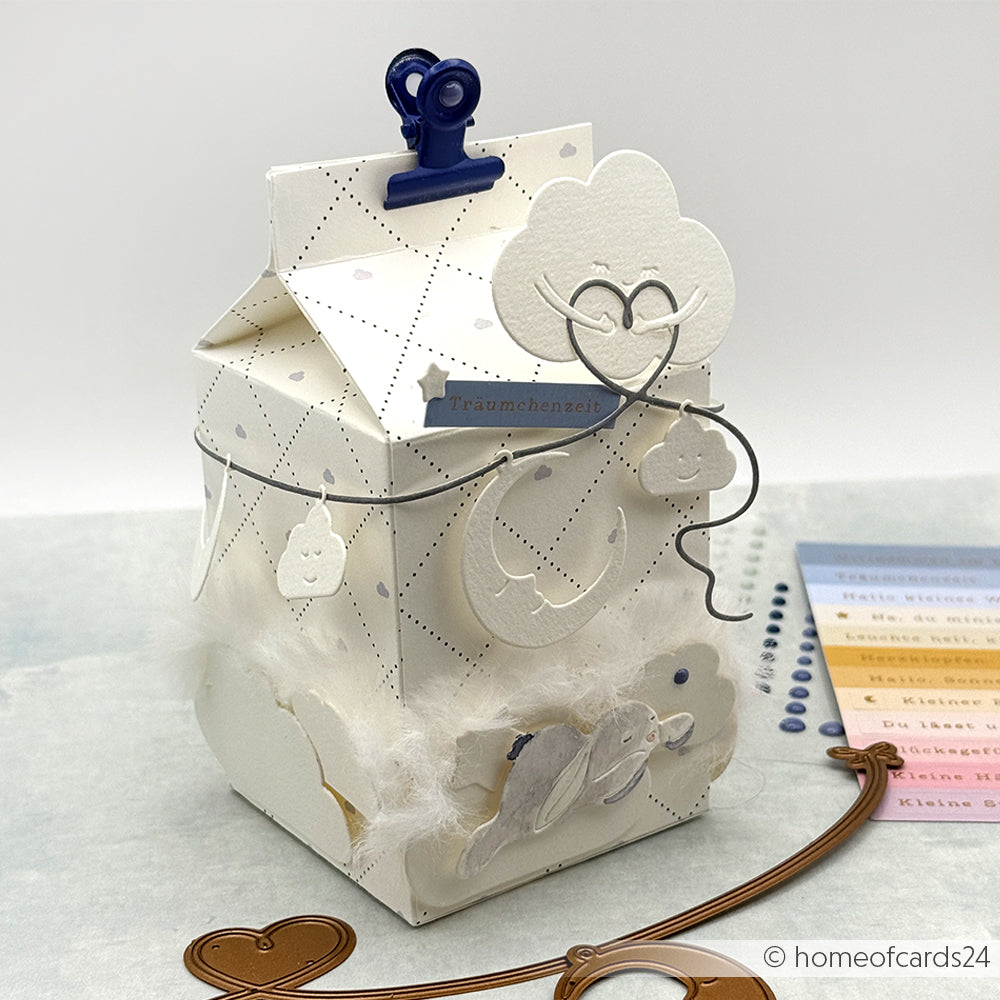 Dekorative weiße Geschenkschachtel von Alexandra Renke mit Wolken-, Mond- und Herz-Akzenten aus Motivstanze, abgeschlossen mit einem blauen Clip.
