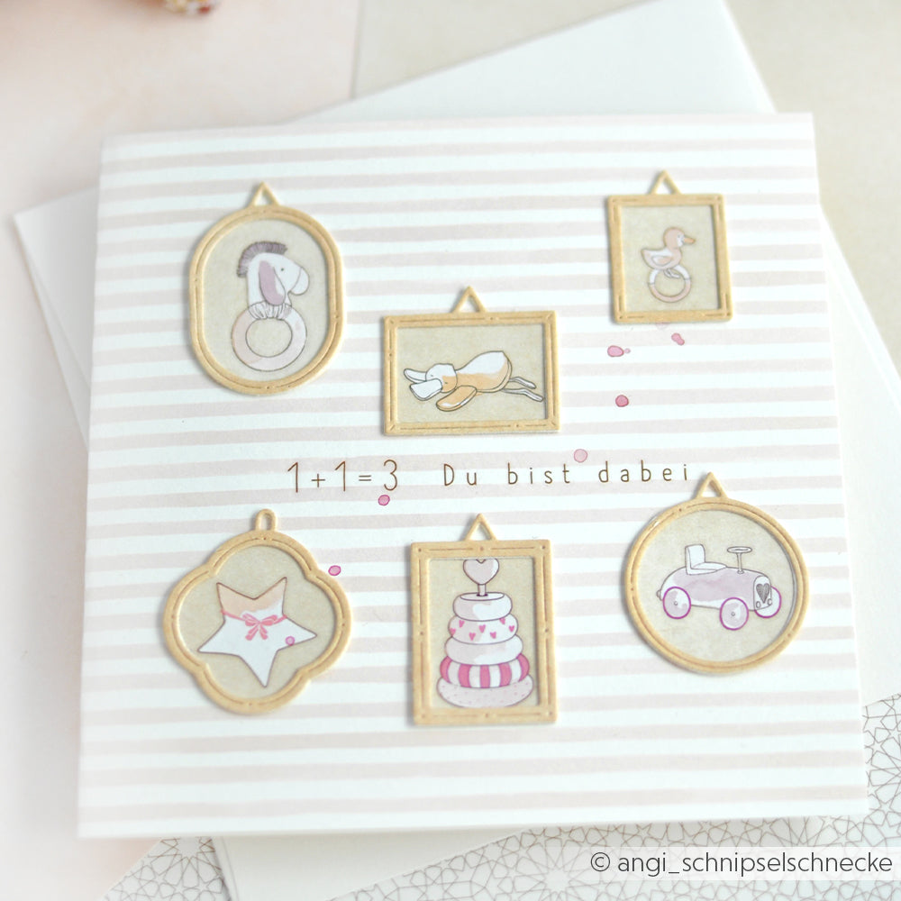 Quadratische Karte aus Alexandra Renke Designpapier mit gerahmten Illustrationen zum Thema Baby und dem Text "1+1=3 Du bist dabei". Akzente werden mit der Alexandra Renke Motivstanze Runde-Rähmchen gesetzt.
